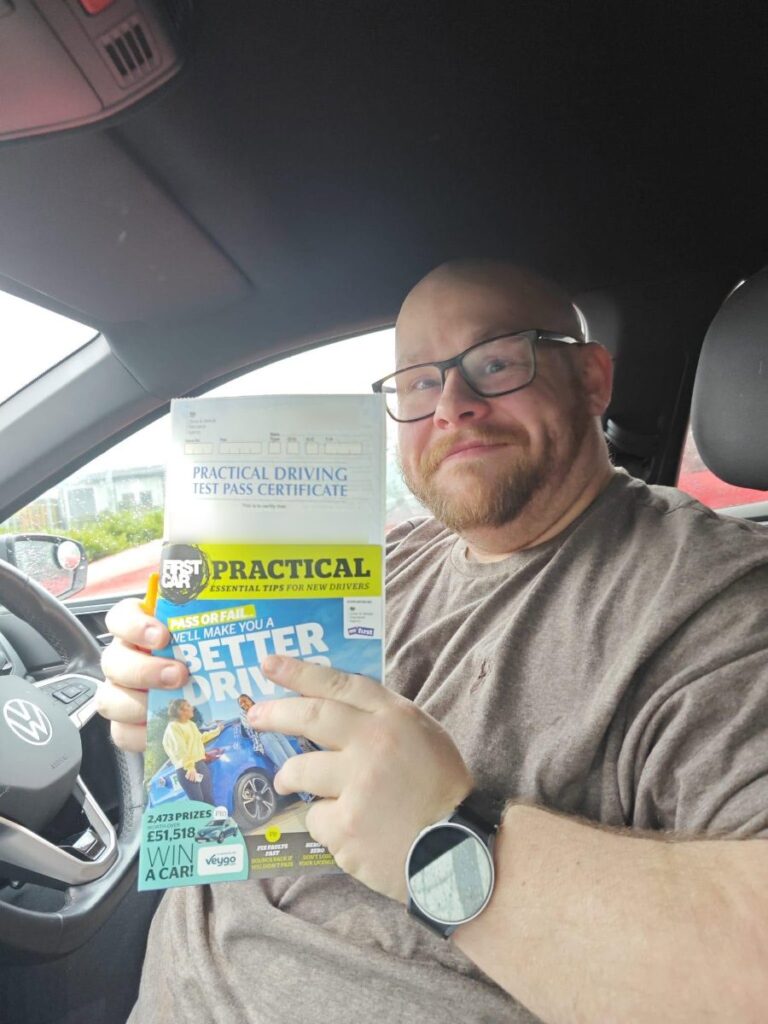 Learner holding their driving test pass certificate with English School of Motoring